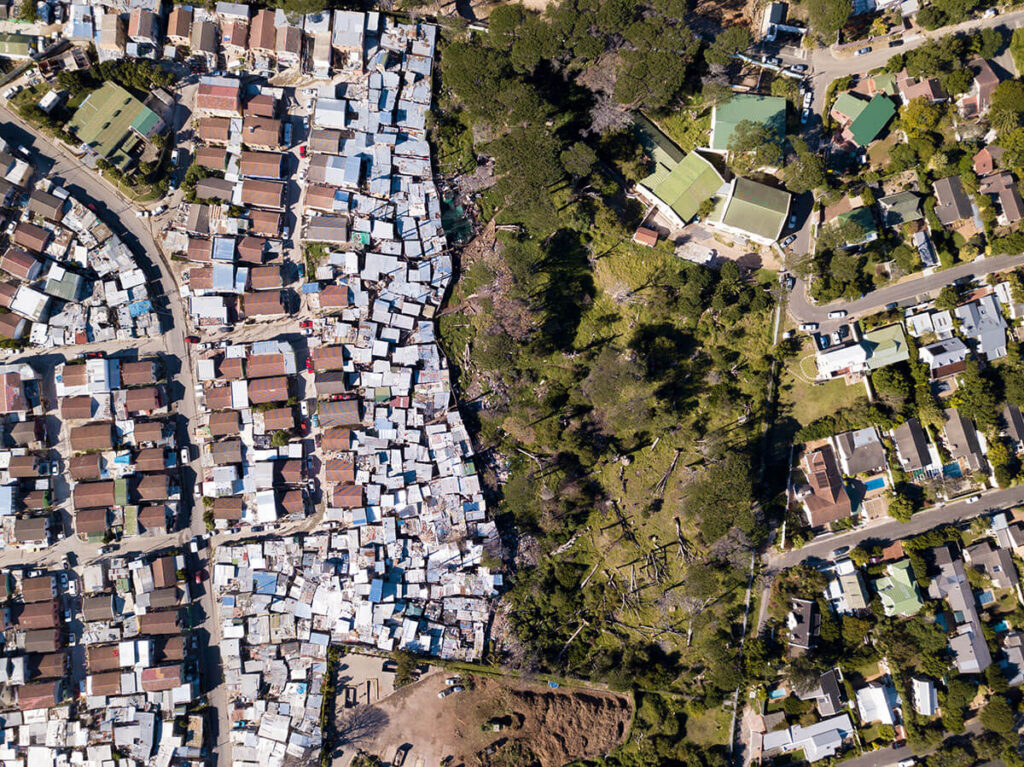 Overhead view of a roomy, suburban neighborhood in contrast to a low income, densely populated neighborhood