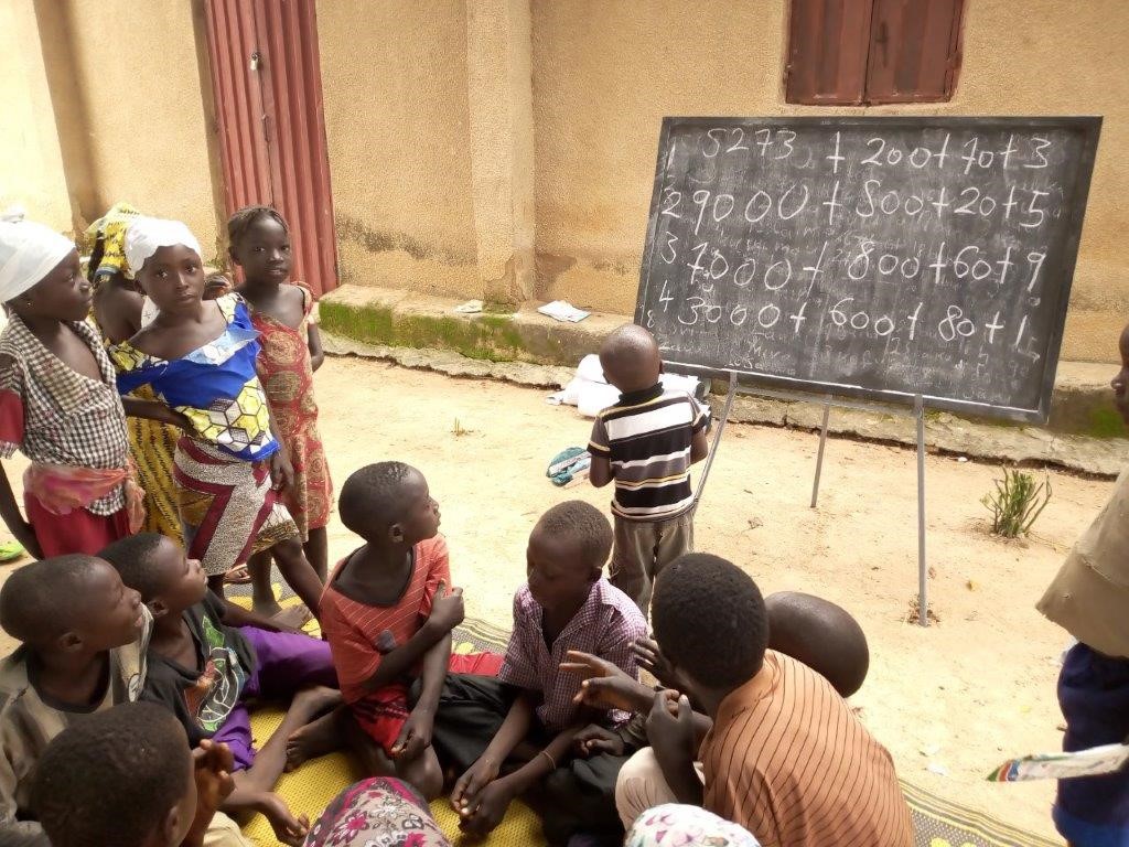 Children look at figures on a chalkboard